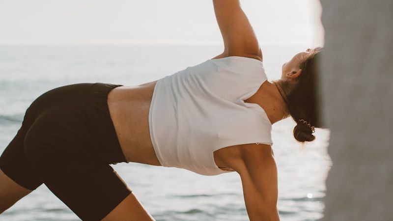 Person practicing yoga outdoors at sunrise, symbolizing energy and vitality.